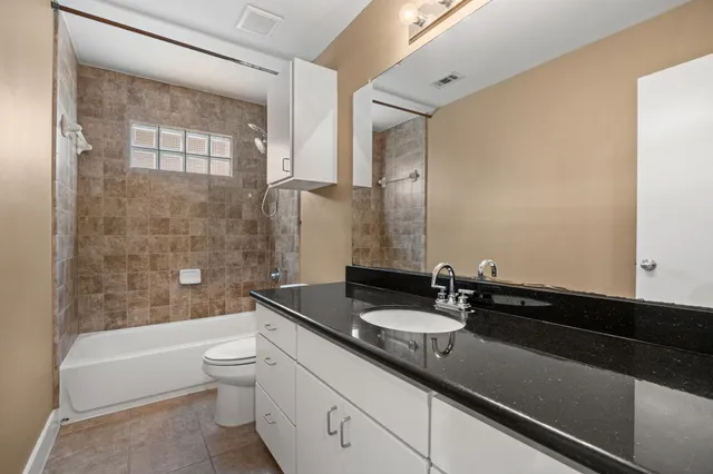 a bathroom with a sink a toilet a mirror and bathtub