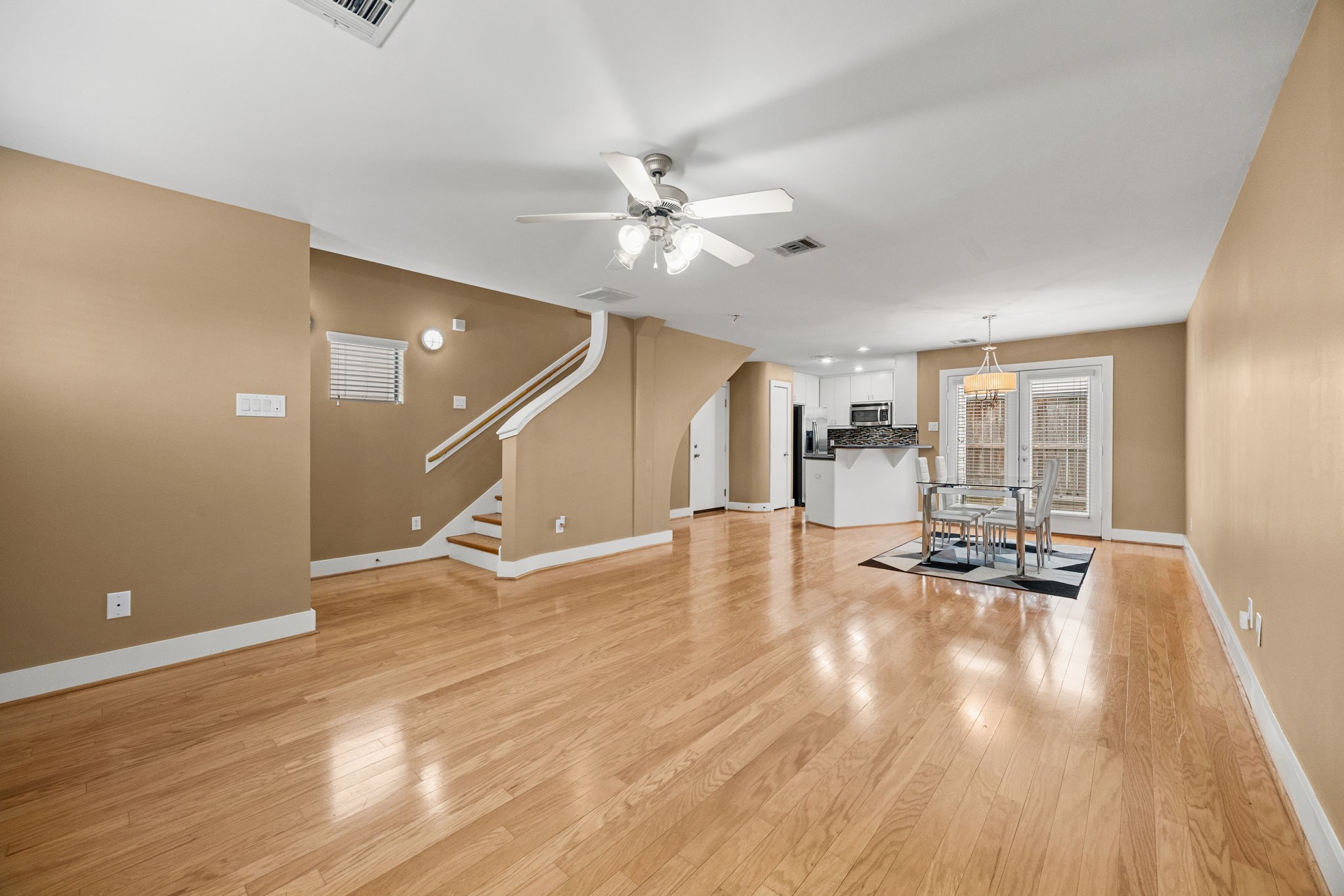 5951 S Loop East, Unit 7 Houston, TX 77033 - Photo 3 of 22 a view of a livingroom with wooden floor and a ceiling fan