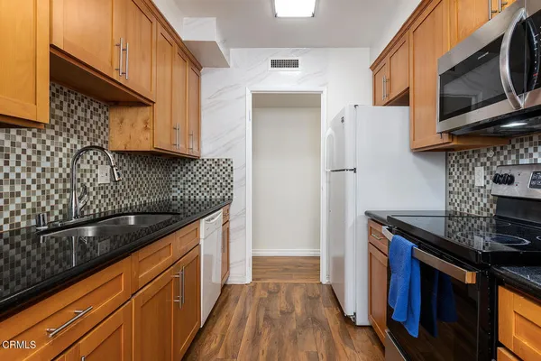 a kitchen with stainless steel appliances granite countertop a sink stove and refrigerator