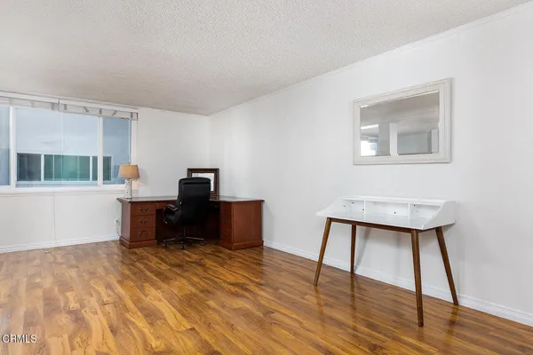 a view of a workspace with furniture and wooden floor