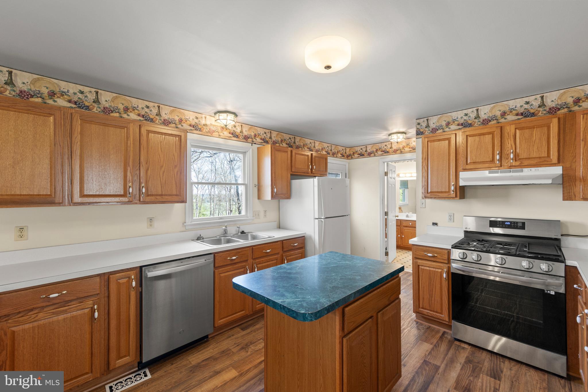 430 Babbs Mountain Road Winchester, VA 22603 - Photo 18 of 49 a kitchen with a stove a sink and a refrigerator