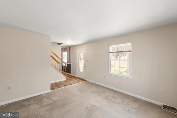 a view of an empty room with a fireplace and a window