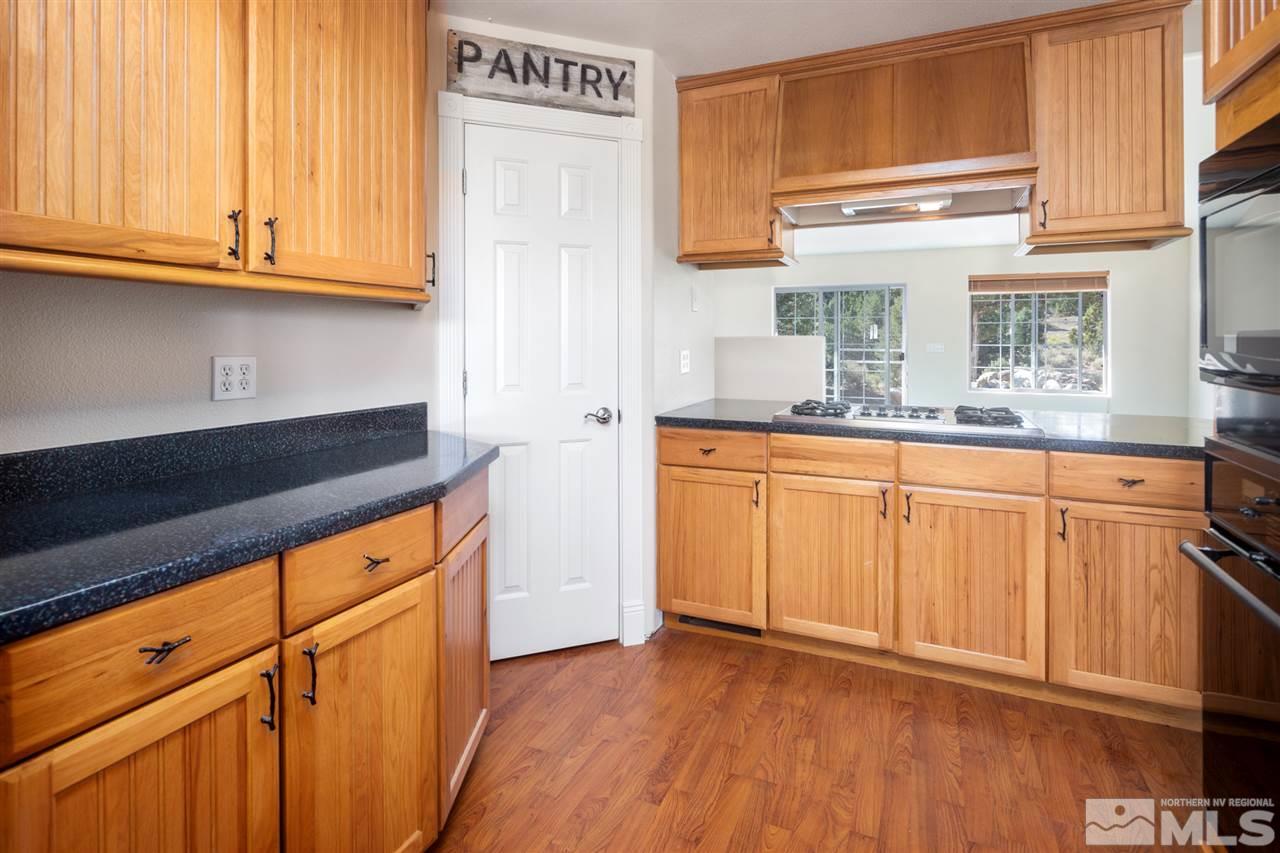 21859 Adobe Road Reno, NV 89521 - Photo 6 of 40 a kitchen with granite countertop white cabinets and sink