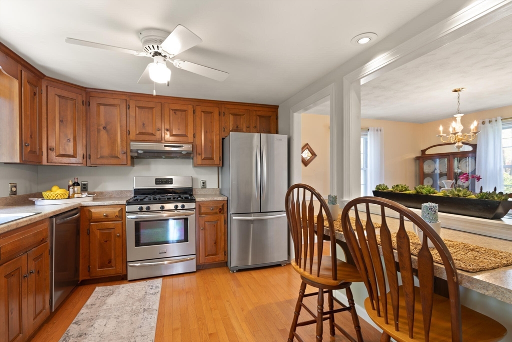 51 Pine Ridge Road Reading, MA 01867 - Photo 16 of 30 a kitchen with stainless steel appliances granite countertop a stove top oven a refrigerator a sink and dishwasher with wooden floor