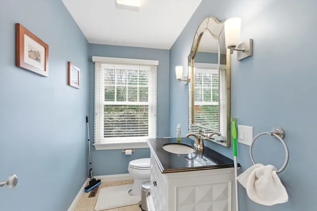 a bathroom with a granite countertop sink mirror vanity and toilet