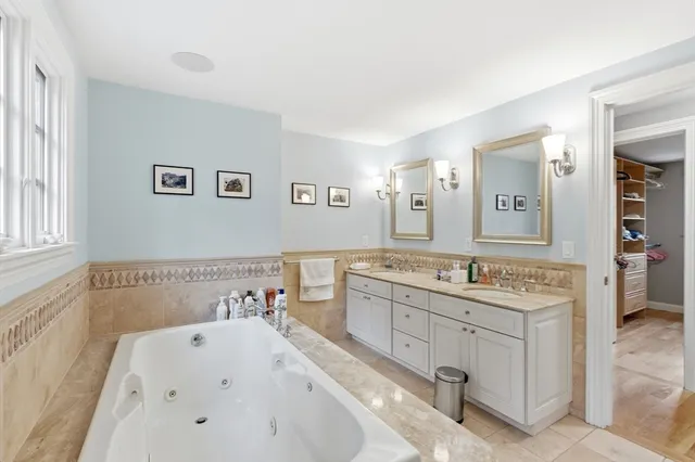 a bathroom with a tub sink and mirror
