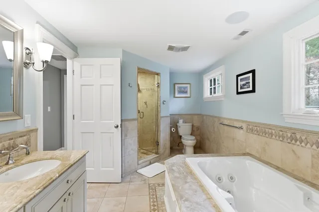 a bathroom with a tub sink and mirror