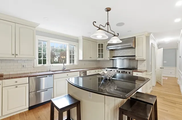 a kitchen with a sink a center island cabinets and stainless steel appliances