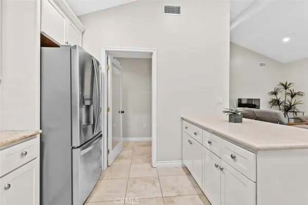 a bathroom with a double vanity sink mirror and refrigerator