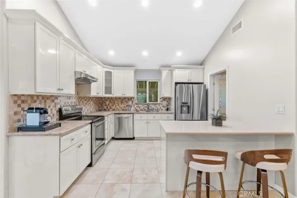 a kitchen with white cabinets and stainless steel appliances