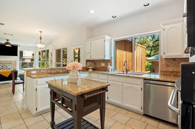 a kitchen with stainless steel appliances granite countertop a stove and a sink