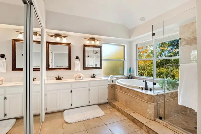 a bathroom with a tub a sink and mirror