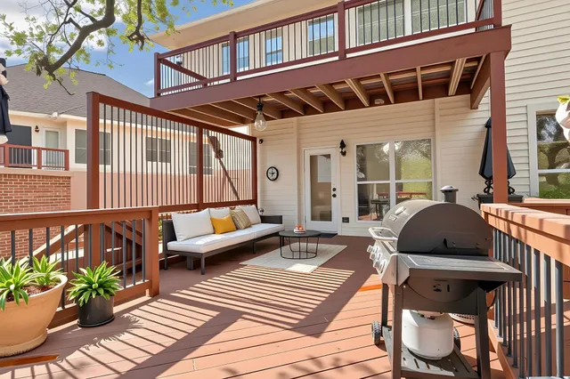 a balcony with wooden floor and outdoor seating