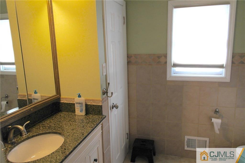 16 Clive Hills Road Edison, NJ 08820 - Photo 15 of 25 a bathroom with a granite countertop sink and a mirror