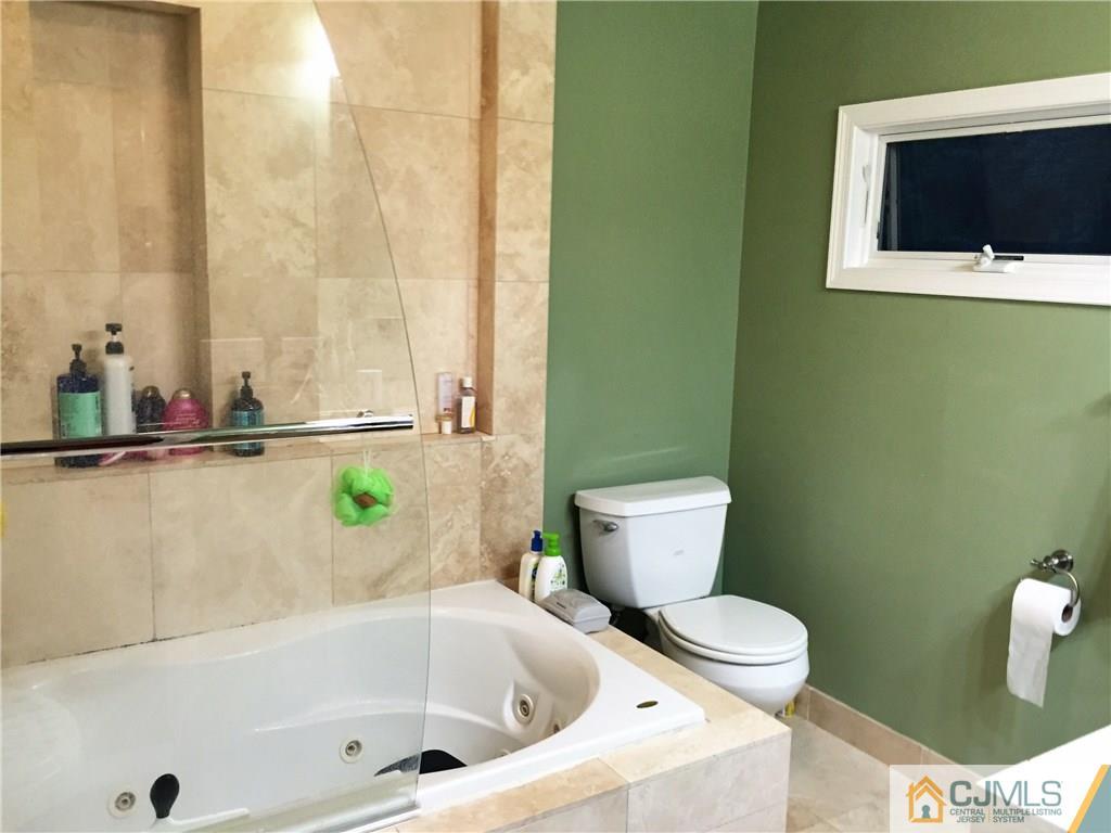 16 Clive Hills Road Edison, NJ 08820 - Photo 16 of 25 a bath room with a toilet and a bath tub