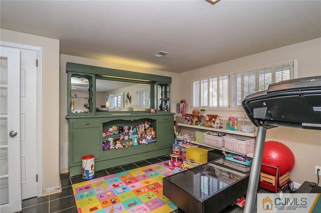16 Clive Hills Road Edison, NJ 08820 - Photo 21 of 25 a living room with furniture a rug and a wall painting