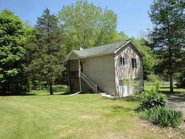 a view of backyard of house with wooden fence