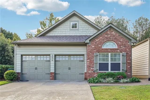 a view of a house with a yard and potted plants