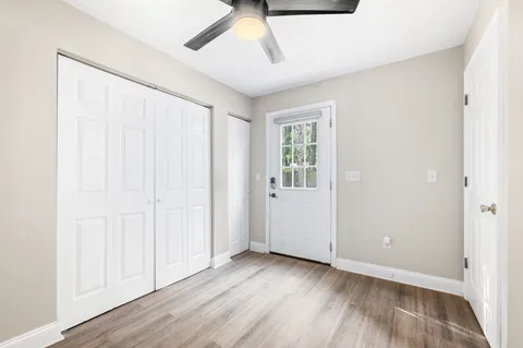an empty room with wooden floor and windows