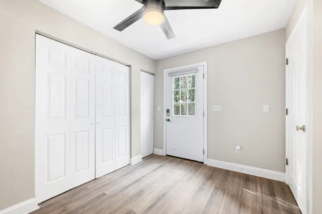 an empty room with wooden floor and windows