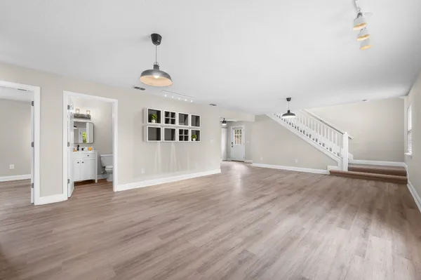 a view of a room with wooden floor and a ceiling fan