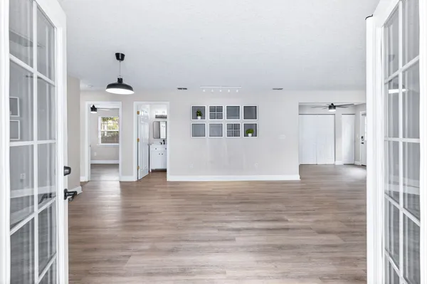 a view of an empty room with a window and wooden floor