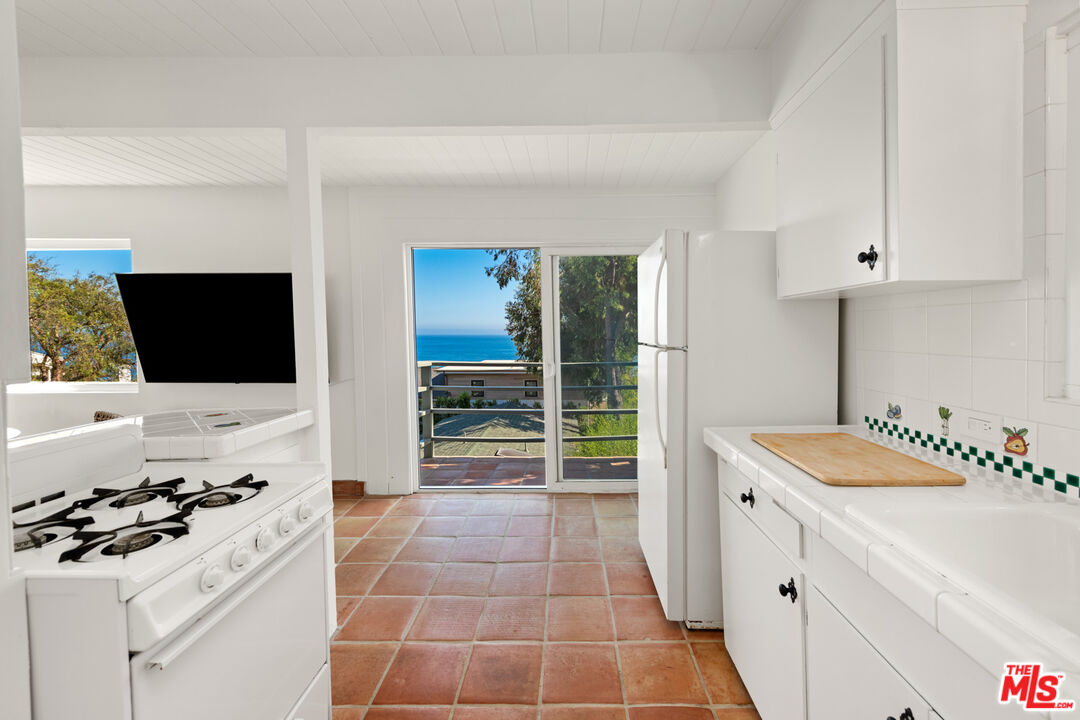 31562 Broad Beach Road Malibu, CA 90265 - Photo 25 of 31 a kitchen with a sink stove and cabinets