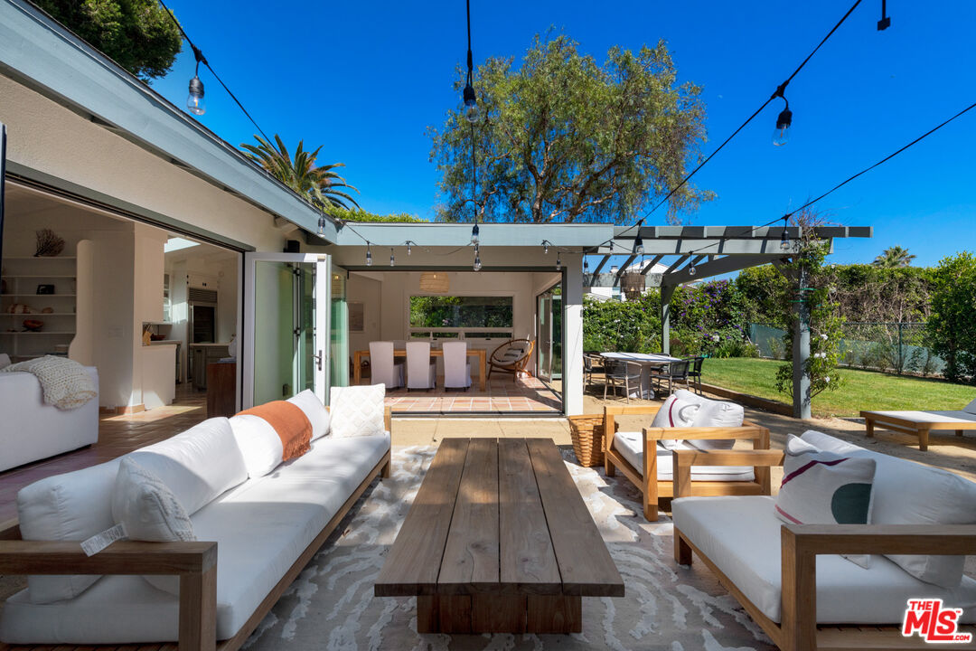 31562 Broad Beach Road Malibu, CA 90265 - Photo 27 of 31 a view of a patio with couches dining table and chairs with wooden floor