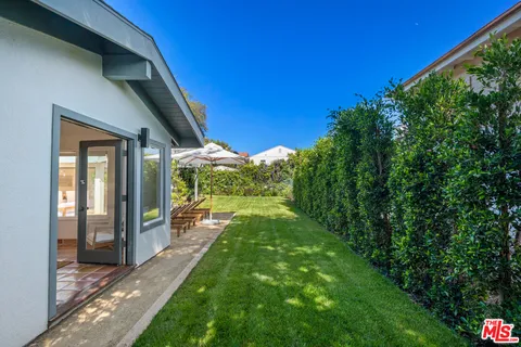 a view of patio with table and chairs under an umbrella