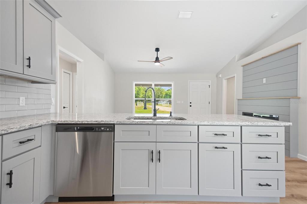 1730 Berrybush Street Bunnell, FL 32110 - Photo 14 of 43 a kitchen with granite countertop white cabinets and white appliances