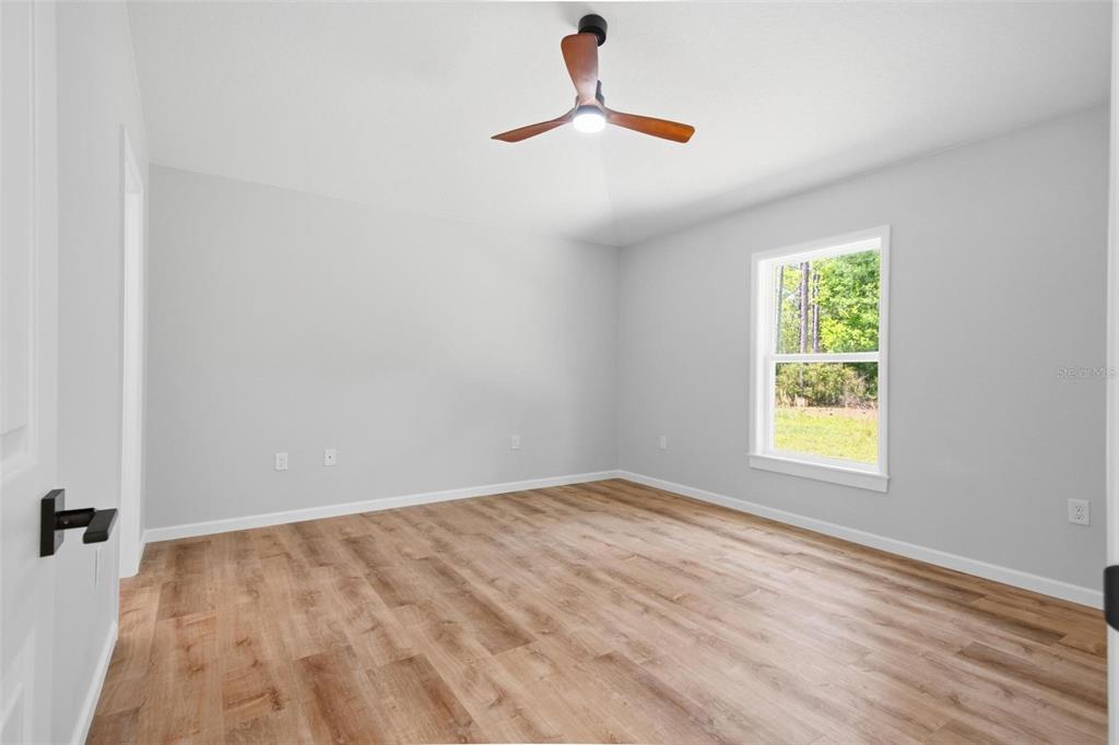 1730 Berrybush Street Bunnell, FL 32110 - Photo 17 of 43 wooden floor in an empty room with a window