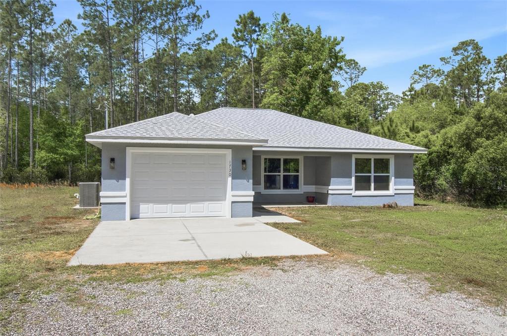 1730 Berrybush Street Bunnell, FL 32110 - Photo 2 of 43 a front view of a house with a garden and porch