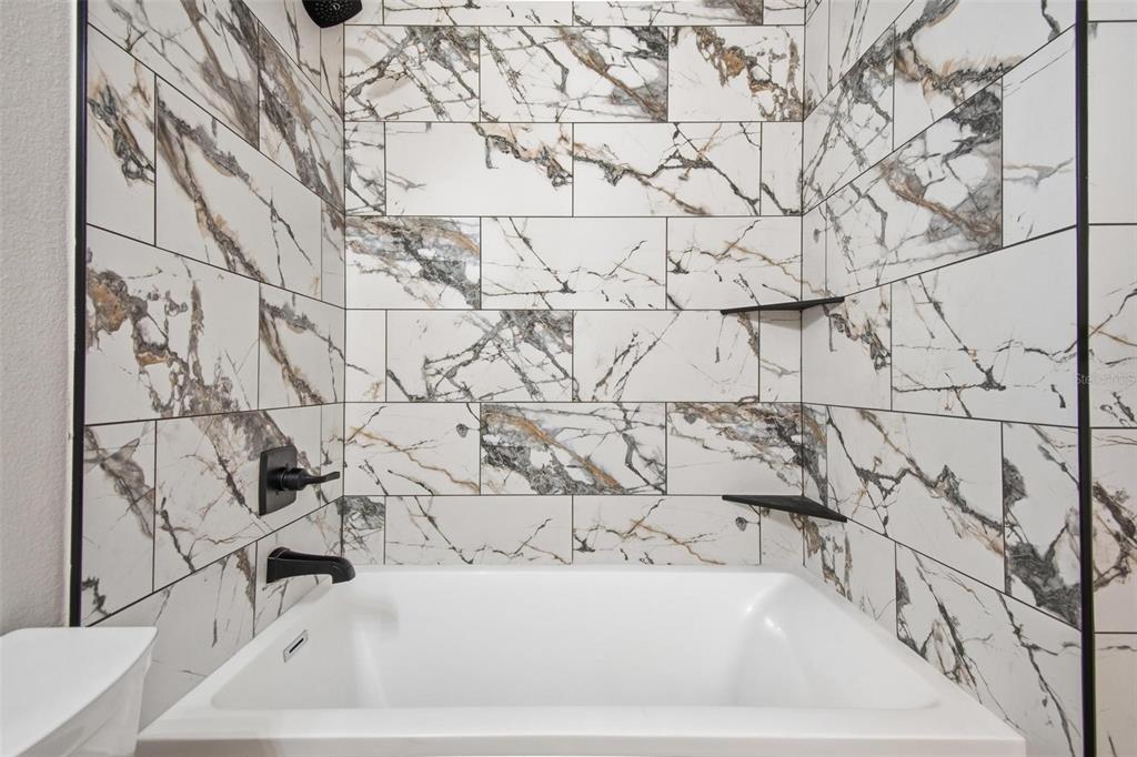 1730 Berrybush Street Bunnell, FL 32110 - Photo 30 of 43 a bathroom with a bathtub and shower