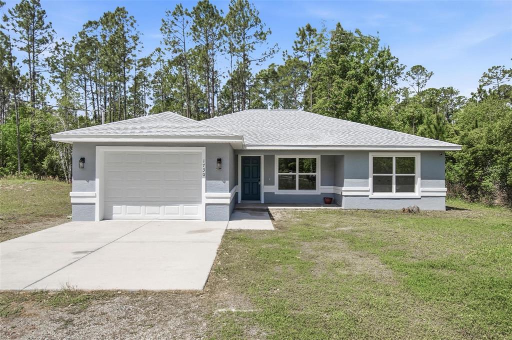 1730 Berrybush Street Bunnell, FL 32110 - Photo 42 of 43 a front view of a house with a garden and trees