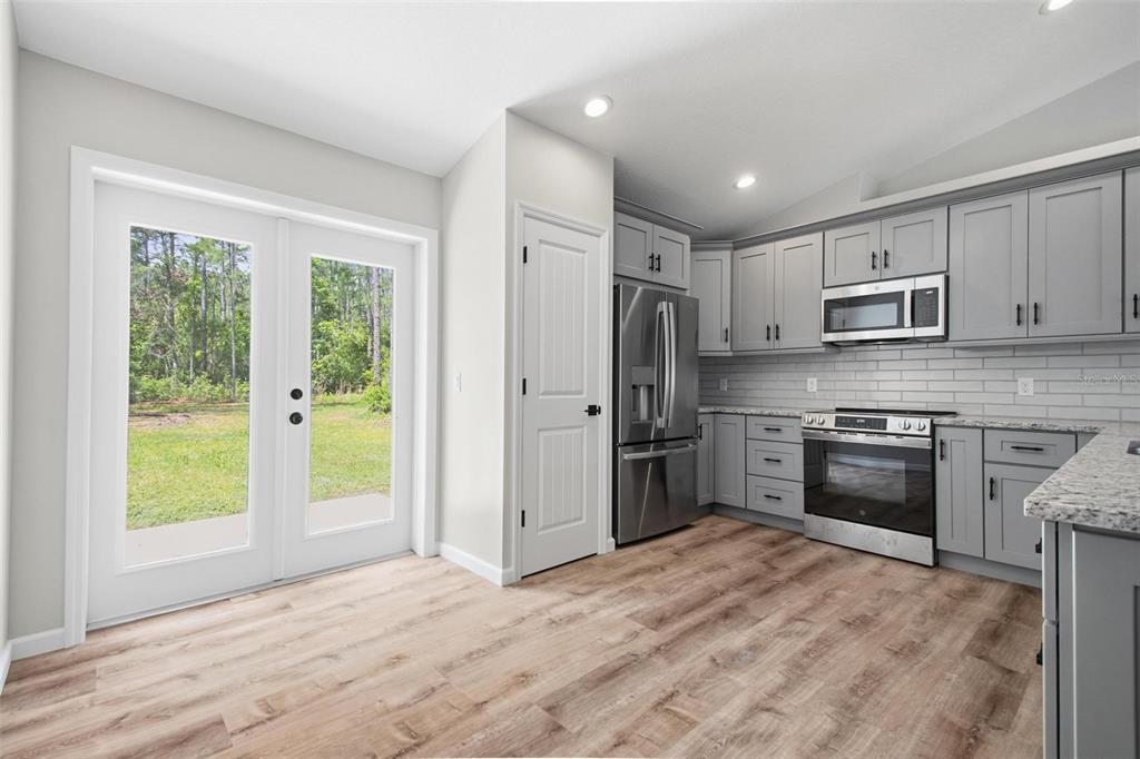 1730 Berrybush Street Bunnell, FL 32110 - Photo 10 of 43 a kitchen with stainless steel appliances a stove a sink and a refrigerator