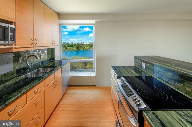a kitchen with stainless steel appliances a stove and a wooden cabinets