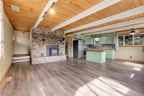 a view of a livingroom with wooden floor and a ceiling fan