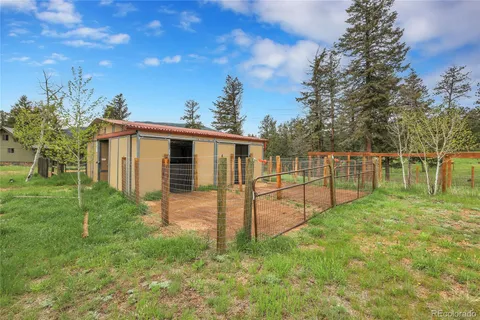 a backyard of a house with plants and large trees