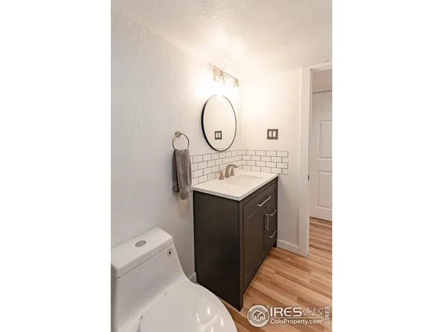 a bathroom with a toilet sink vanity and mirror