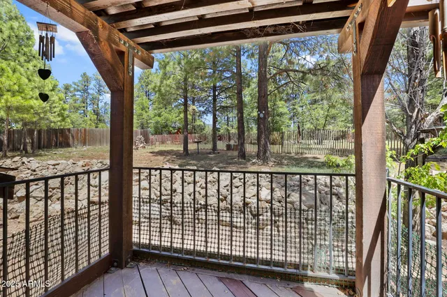 a wooden house covered with trees in the background