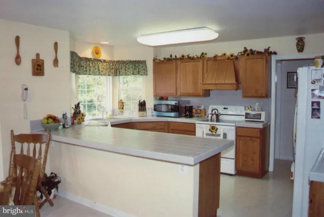 a kitchen with stainless steel appliances granite countertop a sink a stove and a refrigerator