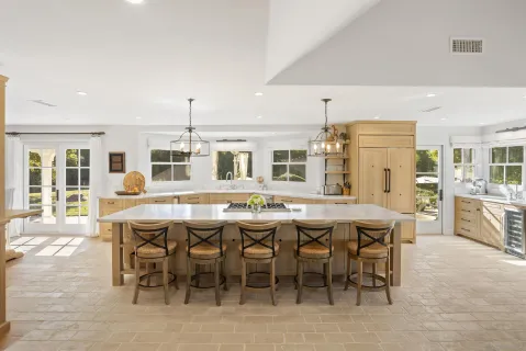 a dining hall with stainless steel appliances kitchen island a table and chairs