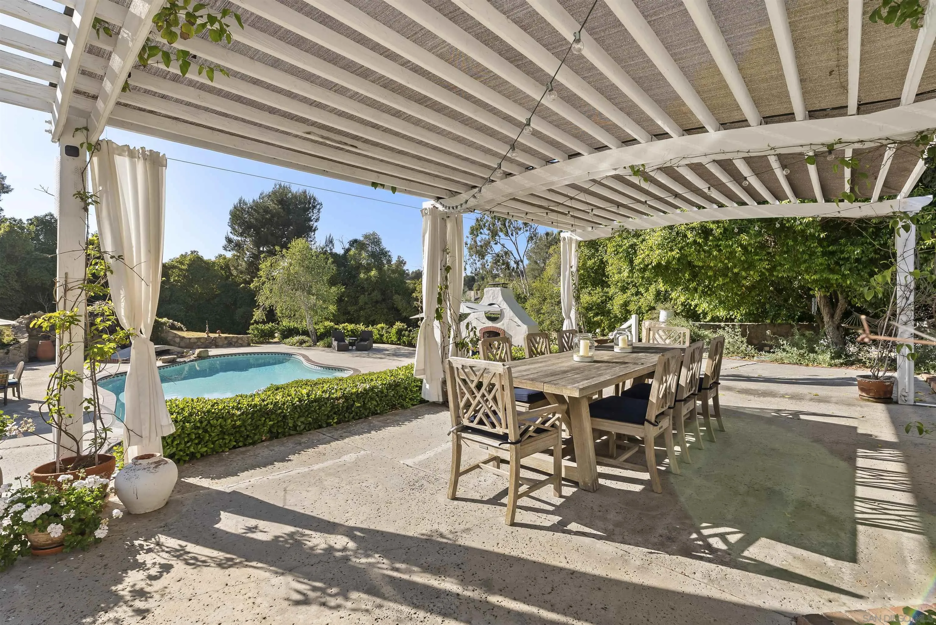 5 Country Glen Road Fallbrook, CA 92028 - Photo 17 of 43 a view of a patio with table and chairs potted plants with wooden floor and fence