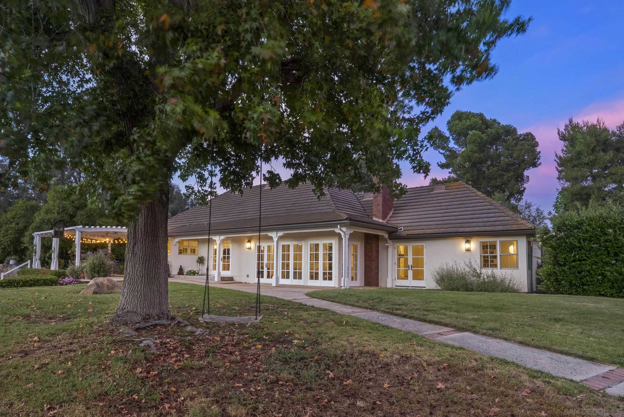 5 Country Glen Road Fallbrook, CA 92028 - Photo 34 of 43 a view of a brick house next to a yard with big trees