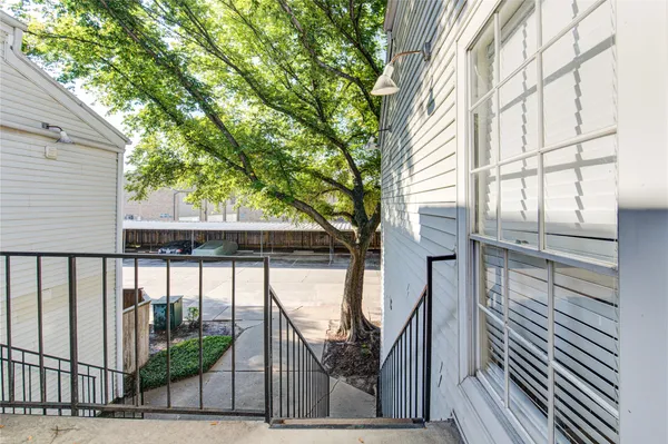 a view of a porch with wooden floor and fence and a bench