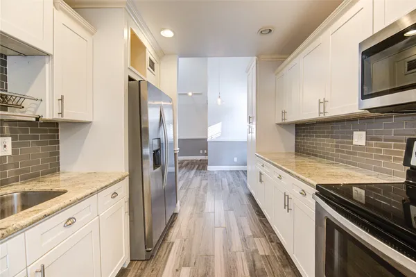 a kitchen with granite countertop stainless steel appliances and wooden cabinets