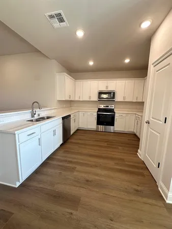 a kitchen with granite countertop a sink stainless steel appliances and cabinets