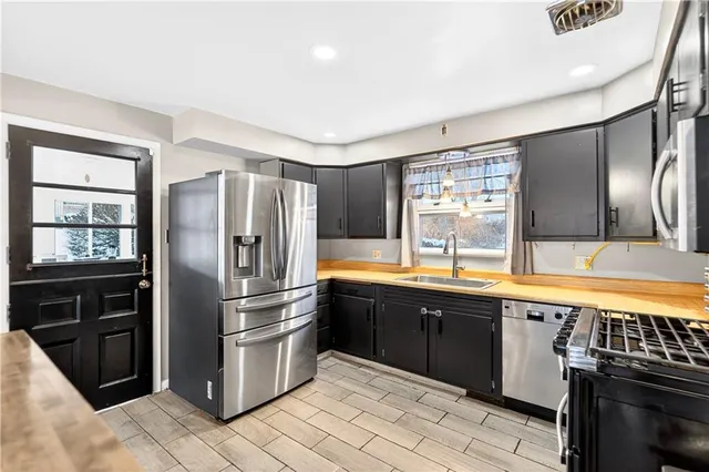 a kitchen with stainless steel appliances granite countertop a refrigerator and a sink
