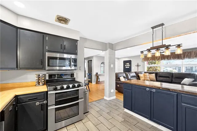 a kitchen with stainless steel appliances kitchen island granite countertop a stove and a sink
