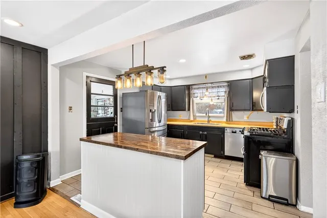 a kitchen with stainless steel appliances granite countertop a sink and a refrigerator